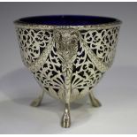 A George V silver sugar basket with pieced scrollwork decoration, the ovoid body with ram's mask and