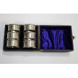 A set of six Victorian silver napkin rings with foliate engraved decoration between raised rims,