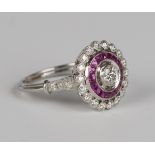 A platinum, diamond and ruby cluster ring, collet set with the principal circular cut diamond within