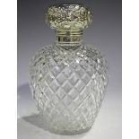 An Edwardian silver mounted cut glass scent bottle and stopper, the hinged lid embossed with
