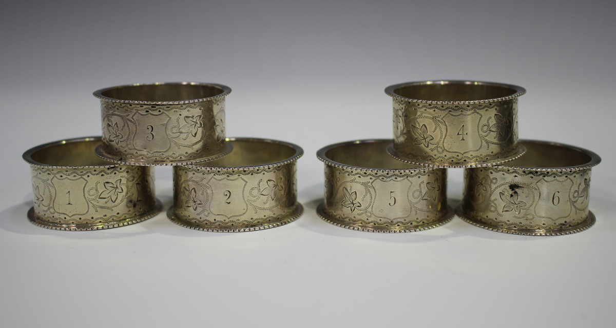 A set of six Victorian silver napkin rings with foliate engraved decoration between raised rims, - Image 3 of 3