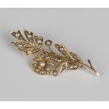 A 15ct gold and half-pearl brooch in a floral and foliate design, detailed '15', weight 4.7g,