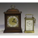 An early 20th century brass carriage alarm clock with eight day movement striking on a bell, the