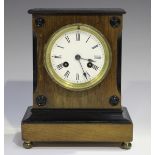 A Victorian walnut mantel clock with eight day movement striking on a bell, the circular white