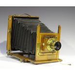 An early 20th century mahogany and gilt lacquered brass folding plate camera with black leather