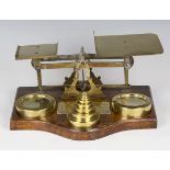A set of large late 19th century brass postal scales and weights, raised on an oak base with applied