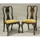 A pair of Queen Anne walnut vase back dining chairs with drop-in seats, on carved cabriole legs,