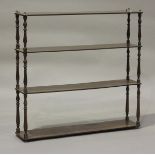 A 19th century mahogany four-tier hanging wall shelf with brass finials and terminals, height