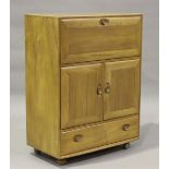 An Ercol elm side cabinet, the fall-flap enclosing two shelves above a double cupboard and