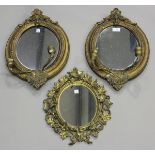 A pair of late 19th century gilt composition oval girandole wall mirrors, height 48cm, width 32cm (