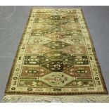A Turkish rug, mid/late 20th century, the faded compartmentalized field within an ivory border,