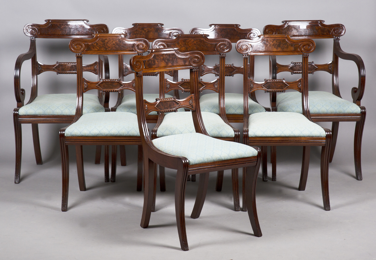 A set of eight Regency figured mahogany bar back dining chairs with carved scroll decoration and