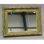 A late 19th century gilt composition rectangular wall mirror, the frame moulded with acanthus leaves