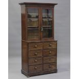 A George IV mahogany bookcase cabinet, the glazed top above eight oak-lined drawers, on bun feet,