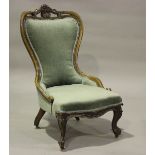 A late Victorian walnut lady's salon armchair, carved with flower and leaf decoration, upholstered