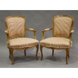 A pair of 20th century Louis XV style beech showframe fauteuil armchairs, upholstered in striped