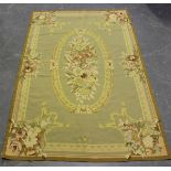 An Aubusson style tapestry rug, late 20th century, the taupe field with an oval floral spray centre,