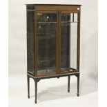 An Edwardian mahogany display cabinet, the frieze inlaid with flowers and ribbon swags, enclosed