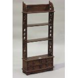 A late 20th century reproduction stained hardwood bookcase, fitted with four drawers, height