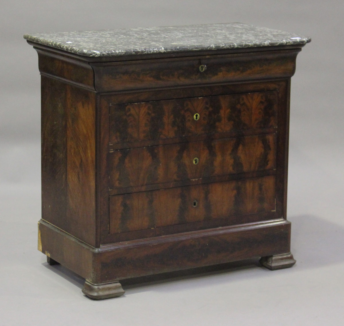 A French Louis Philippe figured mahogany four-drawer commode, the grey marble top above oak-lined