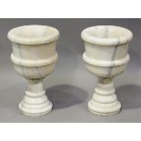 A pair of 20th century turned alabaster urns, raised on stepped circular bases, height 47cm,