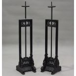 A pair of 20th century Chinese ebonized candle stands with carved foliate bases and rising central