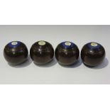 A set of four early 20th century lignum vitae bowling bowls by Taylor Rolph & Co Ltd, inset with