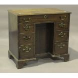 An early 19th century mahogany kneehole desk with crossbanded and ebony line inlaid decoration,