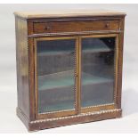 A late Victorian walnut side cabinet, fitted with a drawer above a pair of glazed doors, within bead
