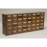 A 19th century mahogany apothecary's bank of forty drawers, most of the drawer fronts with applied