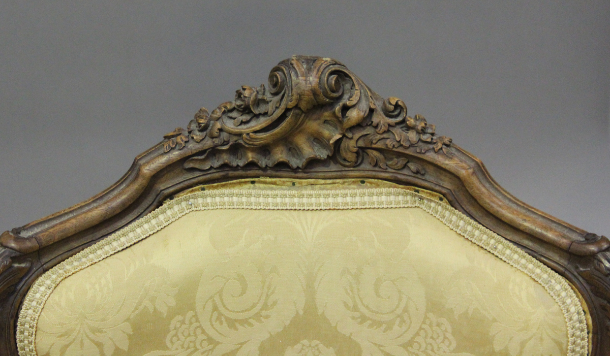 A late 19th century French Louis XV style walnut showframe salon suite, comprising a settee, - Image 2 of 12