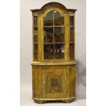 An 18th century Continental walnut floor-standing corner cabinet with an arched cavetto moulded