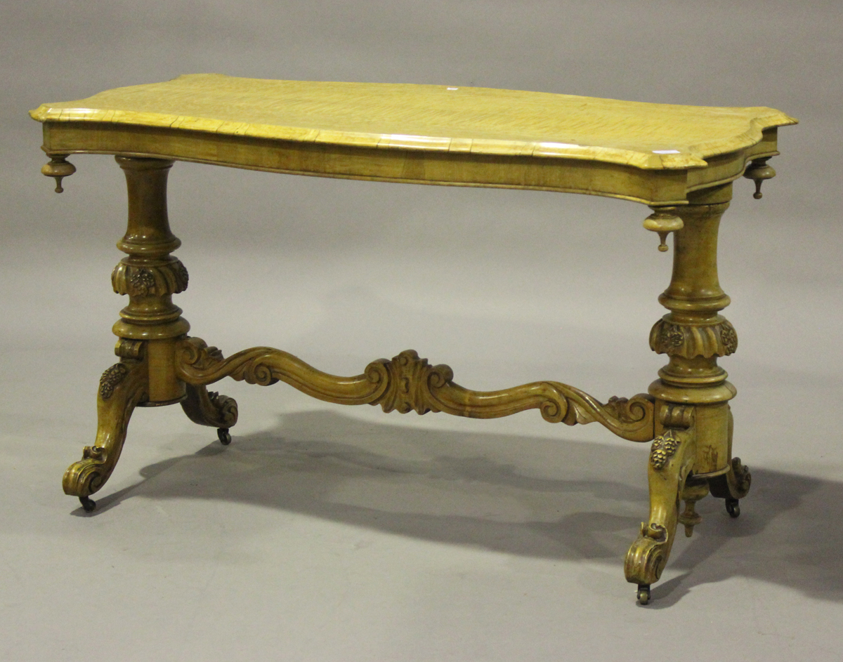 A mid-Victorian birds' eye maple and satin walnut centre table, the serpentine top above a pair of