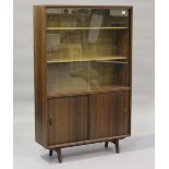 A mid-20th century hardwood bookcase by Herbert Elsibb Autographed Furniture, fitted with sliding