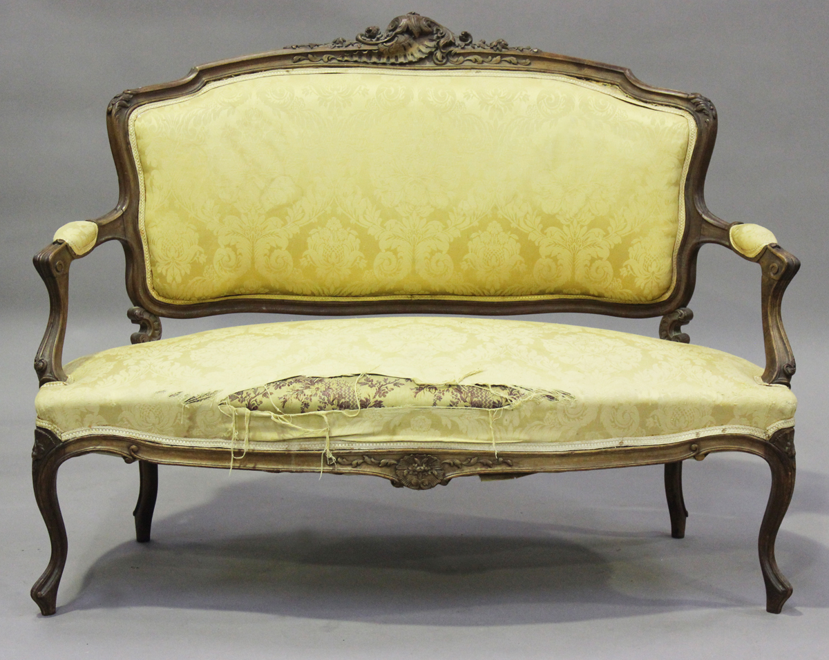 A late 19th century French Louis XV style walnut showframe salon suite, comprising a settee,