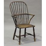 A mid-19th century primitive ash, beech and elm Windsor armchair, the armrests on shaped supports,