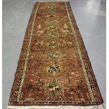 A Karajar runner, North-west Persia, mid-20th century, the faded red field with a column of shaped