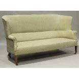 An Edwardian wing back settee, upholstered in foliate patterned cotton, on mahogany square