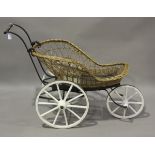 A late 19th/early 20th century woven wicker and wrought iron framed three-wheeled barrow, height