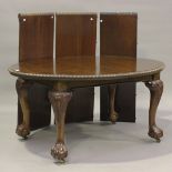 A George V mahogany extending dining table, the gadrooned oval top with two extra leaves and another