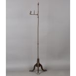 An 18th century iron floor standing rush light, the stem with an adjustable fitting with upright