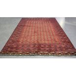 An Afghan bokhara style carpet, mid/late 20th century, the deep claret field with overall columns of