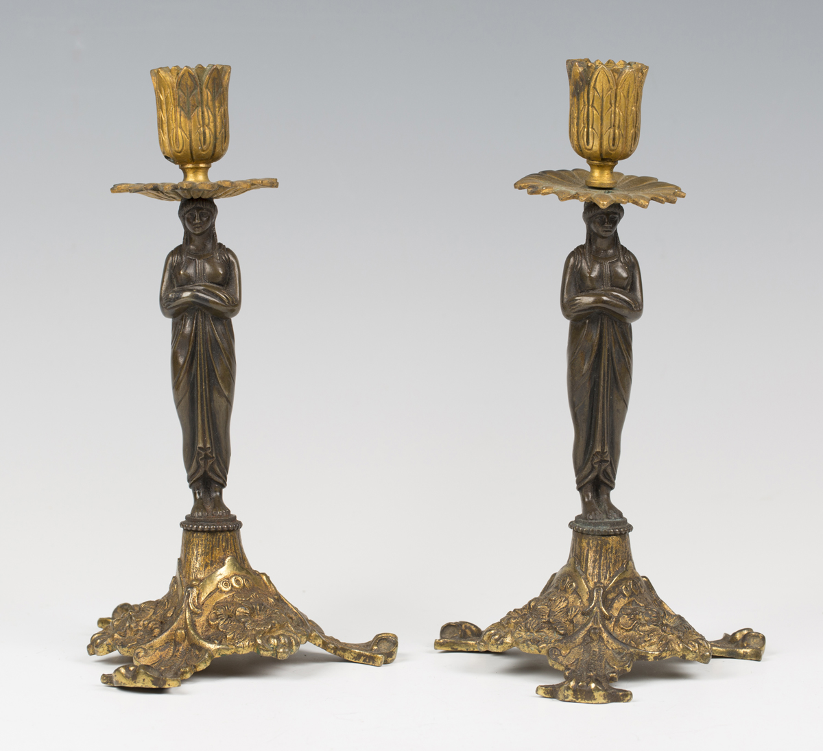 A pair of 19th century brown patinated and gilt bronze figural candlesticks, the classical female