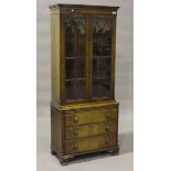 A 20th century reproduction mahogany display cabinet, the glazed doors above drawers, height