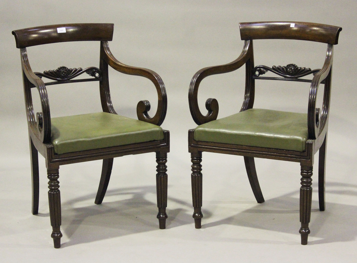 A pair of George IV mahogany bar back elbow chairs with foliate carved centre rails and green