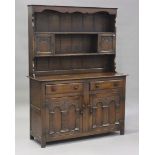 A 20th century Jacobean Revival oak dresser, the shelf back fitted with cupboards, the base with two