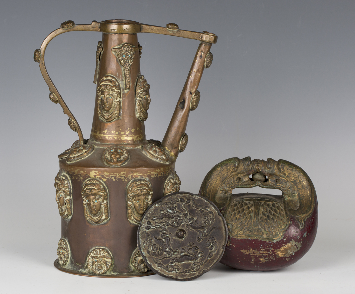 A 19th century copper and brass mounted ewer, applied with overall masks inset with turquoise