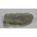 A Chinese pale celadon jade brushwasher, carved as a lotus leaf enveloped by its cut stem, leaves,