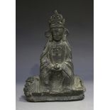 A Chinese cast bronze figure of Guanyin, probably Ming dynasty, modelled seated on the back of a