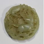 A Chinese jade circular pendant, probably 20th century, carved and pierced with a qilin on